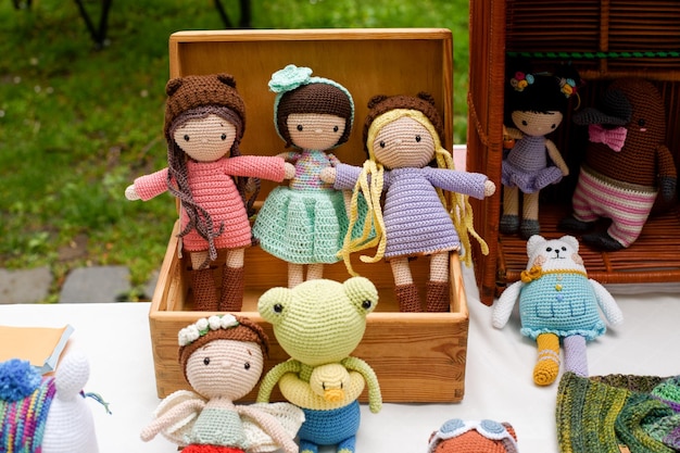 Four handmade knitted toys on wicker shelf