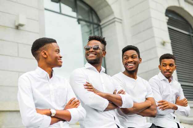 Четыре красивых молодых африканца в белых рубашках