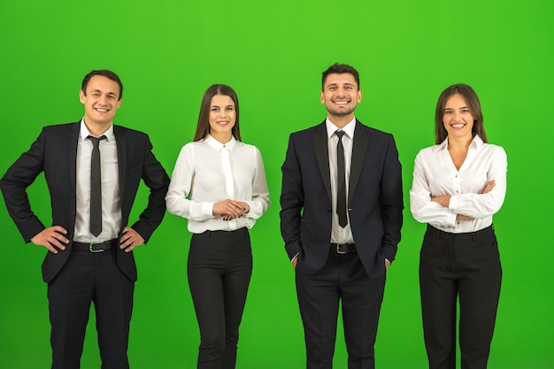 The four happy people stand on the green background