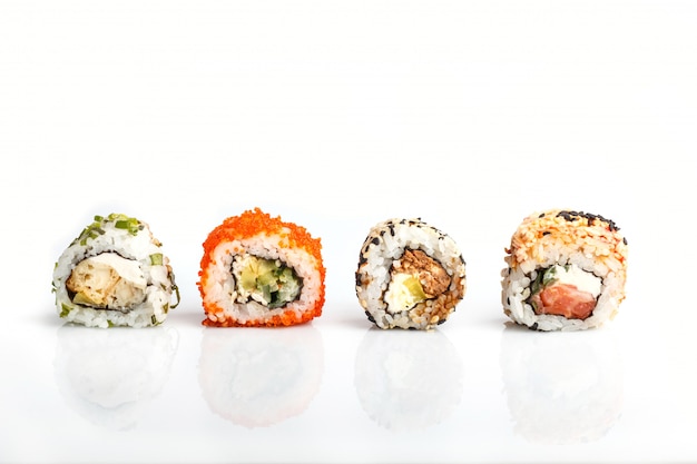 Four Japanese maki sushi rolls in a row with salmon isolated on white