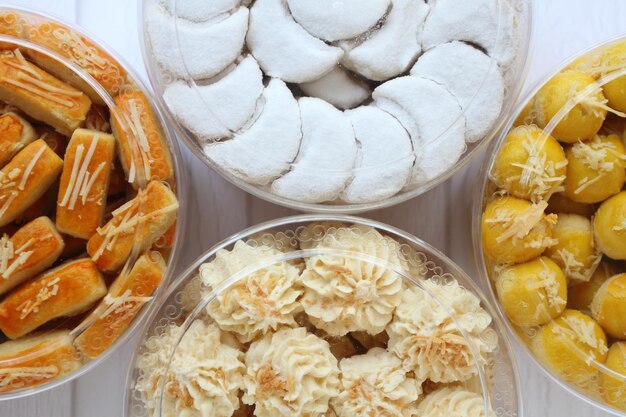 Four jars of Nastar Kaasstengels Vanillekipferl and Cassava Cheese Cookies in half composition