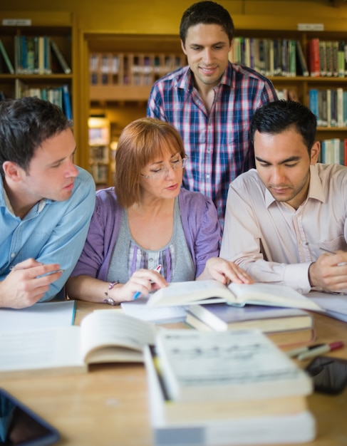 Four mature students studying together in the library