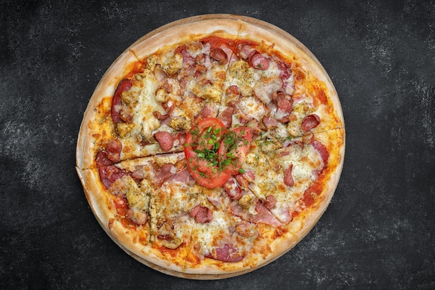 Four meat pizza on a wooden board on gray concrete top view