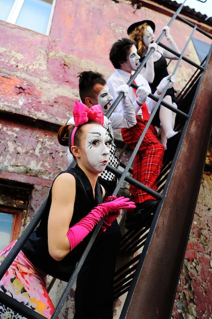 Four mime on the stairs portray emotions