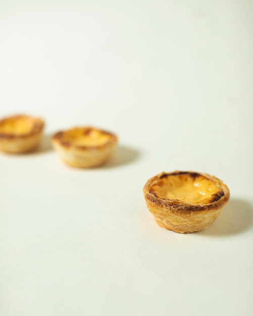 Four mini tarts with one that has a cheese filling on it.