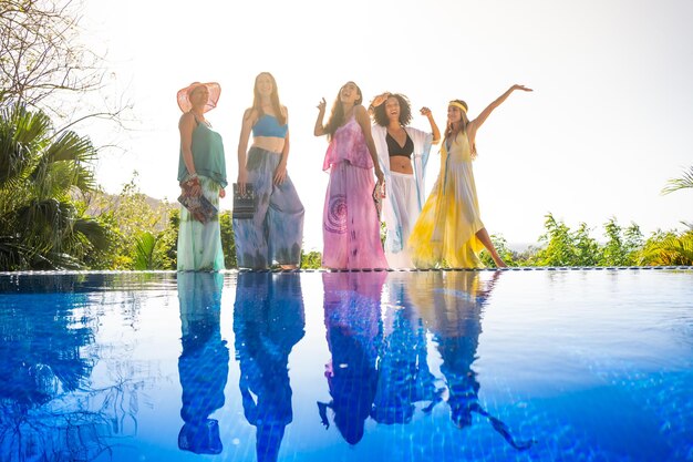 Four models standing on the edge of an outdoor pool