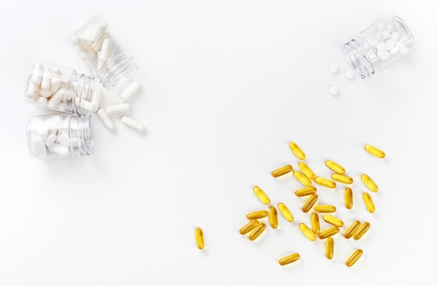 다양 한 흰색 알 약 및 흰색 배경에 황금 정제 4 패키지. 건강 개념. 복사 공간이있는 상위 뷰.