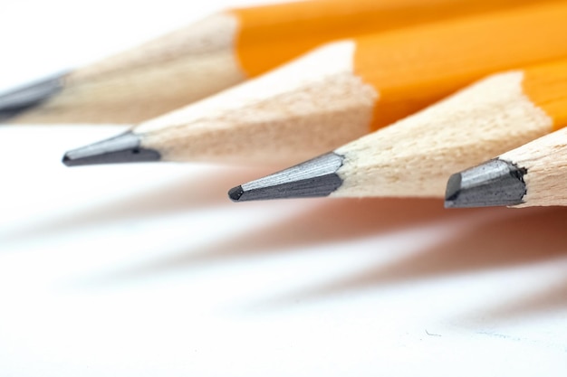 Four pencils on white background macro photo