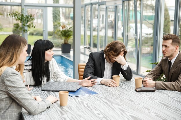 Four people are sitting in the meeting room