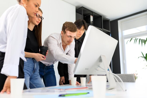 Four people of different nationalities are working on a project in the office