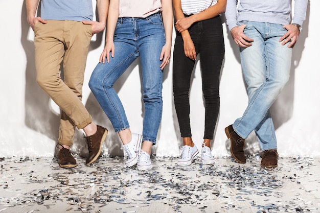 Photo four people dressed in jeans standing on a floor