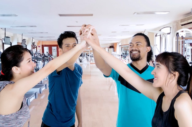 Four people make high five hand gesture