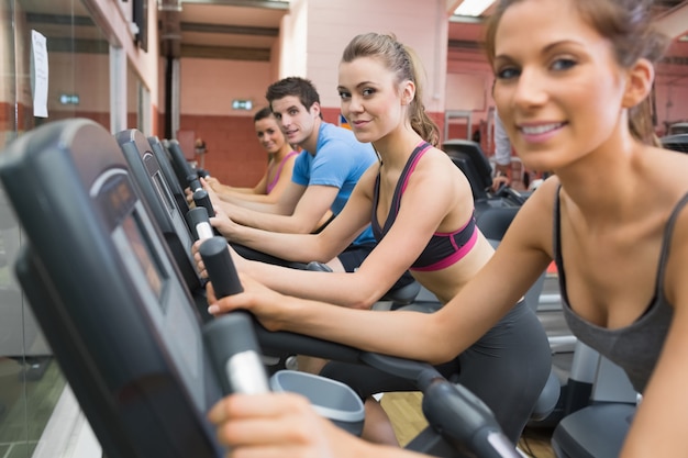 Four people working out on exercise bikes