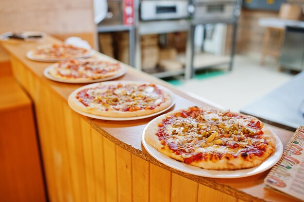 Photo four pizza in restaurant kitchen ready for order.