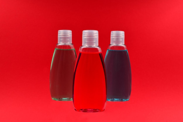 Quattro bottiglie di plastica con sapone liquido giallo, verde e rosso.