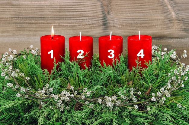 Four red burning candles. Advent decoration Christmas tree branches