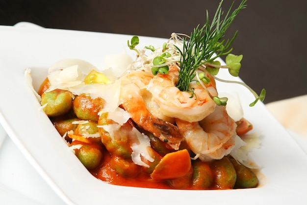 Four shrimps with caper and artichoke on the table