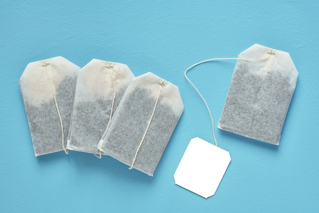 Photo four tea bag and white label on blue