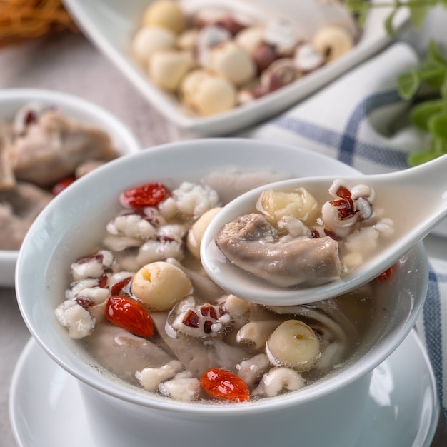 Four Tonics Soup. Close up of delicious homemade Taiwanese traditional Chinese herb flavor food with herbs, pork intestine on gray table surface