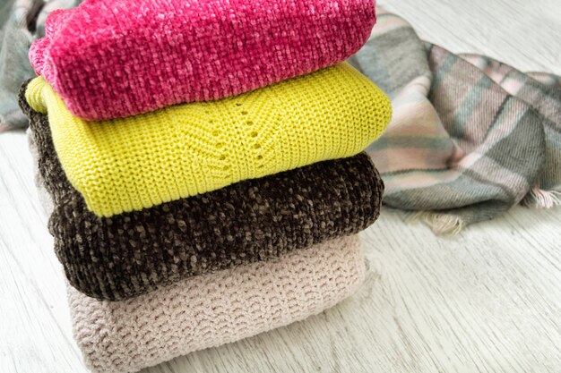 Four warm colour sweaters on a wooden background