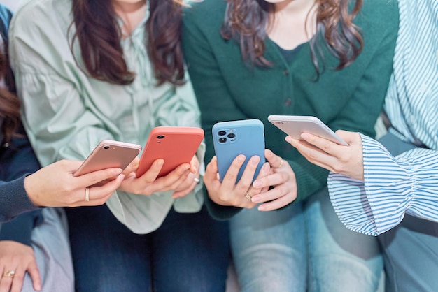 Four women talking while looking at a smartphone