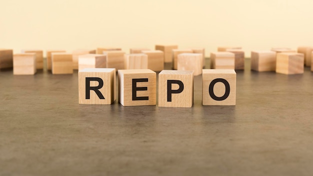 Four wooden blocks with the letters REPO on the surface table REPO Repurchase Agreement