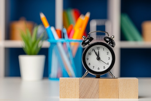 Photo four wooden cubes and alarm clock on desk