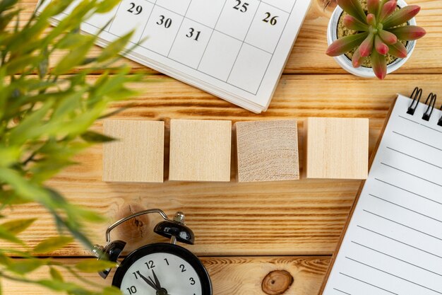 Four wooden cubes with copy space and alarm clock