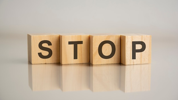 Four wooden cubes with letters stop. Business marketing concept.