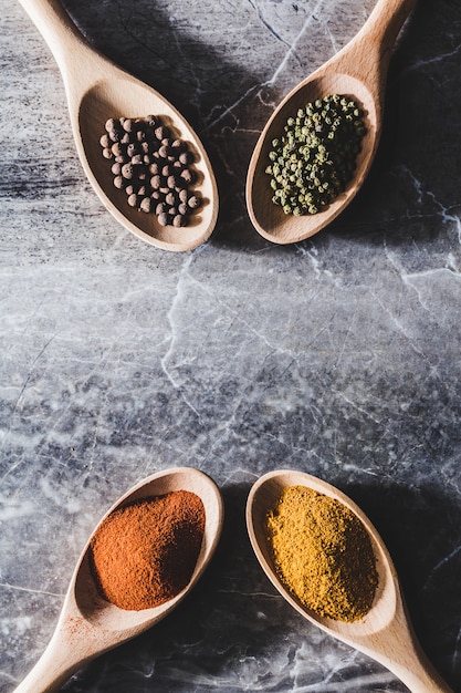 Four wooden spoons with colorful spices