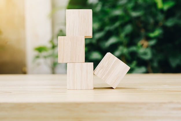 Four wooden toy cubes on wooden table background with copy space