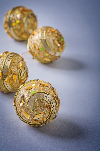 Four yellow christmas baubles on light gray.