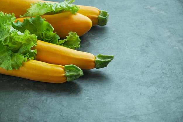 Quattro zucchine e lattughe gialle sul tavolo da cucina