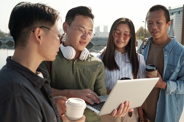 Four young Chinese employees gathered for working meeting