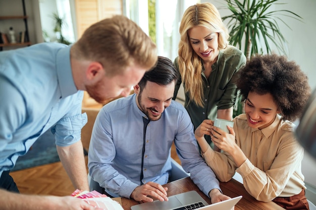 コンピューターの画面を見ている4人の若者