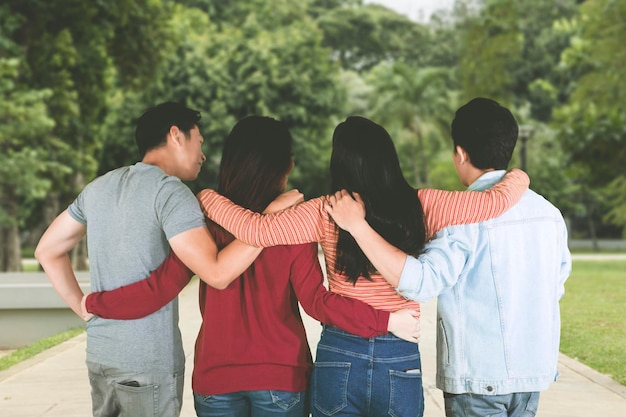 Four young people walking together in the park