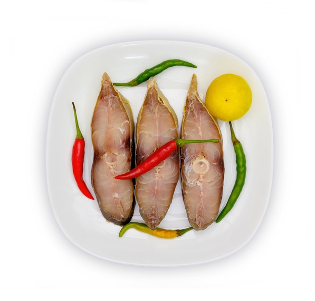 Сушеные рыбы с белой тарелкой, выделенные на белом фоне.