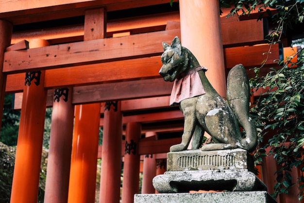 Fox sculptuur met rode toriipoorten bij Fushimi Inari Taisha Shrine in Kyoto, Japan