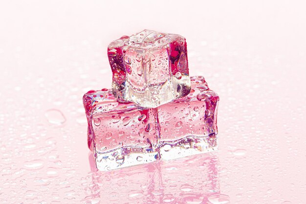 Fozen ice cubes on wet pink surface