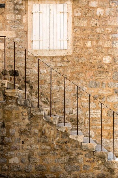 Foto frammento di un antico edificio con una scala nella città vecchia di budva, montenegro