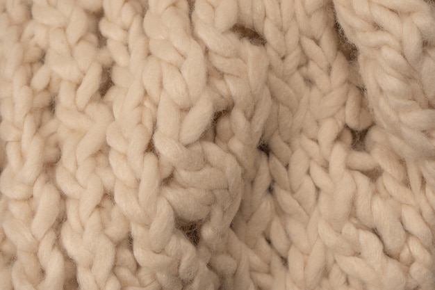 A fragment of beige knitted fabric knitted from white sheep wool