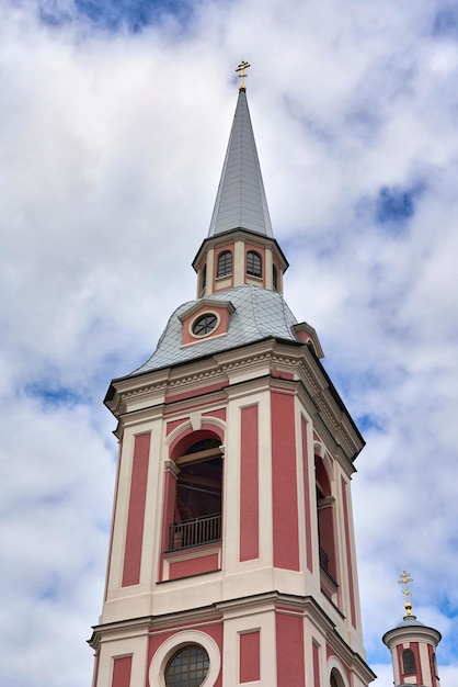 Fragment of the bell tower of a pink christian church