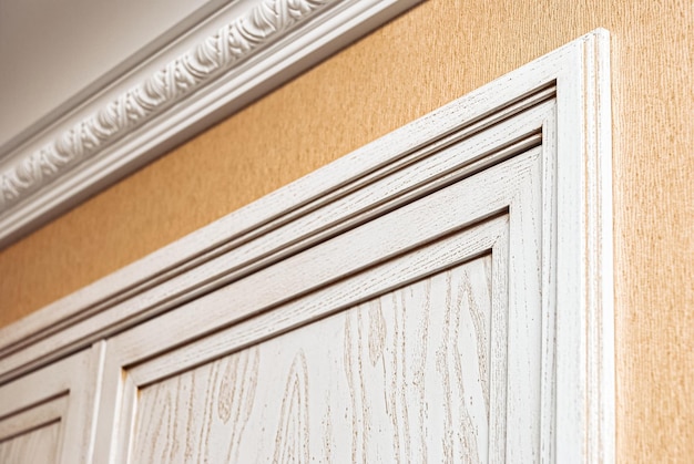 Fragment of builtin wardrobe made of veneer and solid ash in light enamel with gray patina