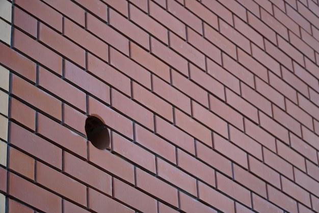 A fragment of a ceramic brick wall closeup with round hole diamond drilling