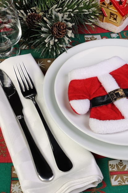 Fragment of the Christmas table serving coat of Santa Claus with cutlery