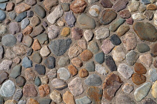 a fragment of a city wall made of natural stone of various colors and textures