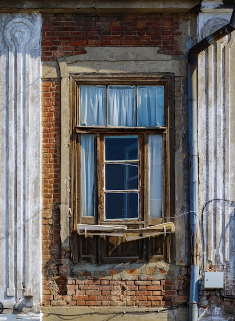 Photo fragment of facade of old brick house with window and drainpipe picture was taken in russia