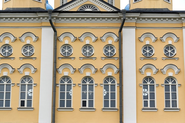 fragment of the facade of the palace with windows and a yellow wall