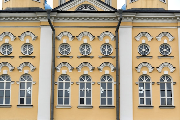 Photo fragment of the facade of the palace with windows and a yellow wall