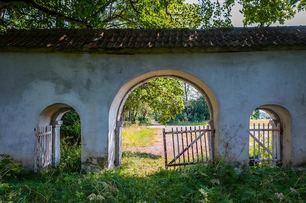 Frammento di una recinzione con un cancello alla tenuta recinzione ad arco con balaustra vecchia casa padronale abbandonata
